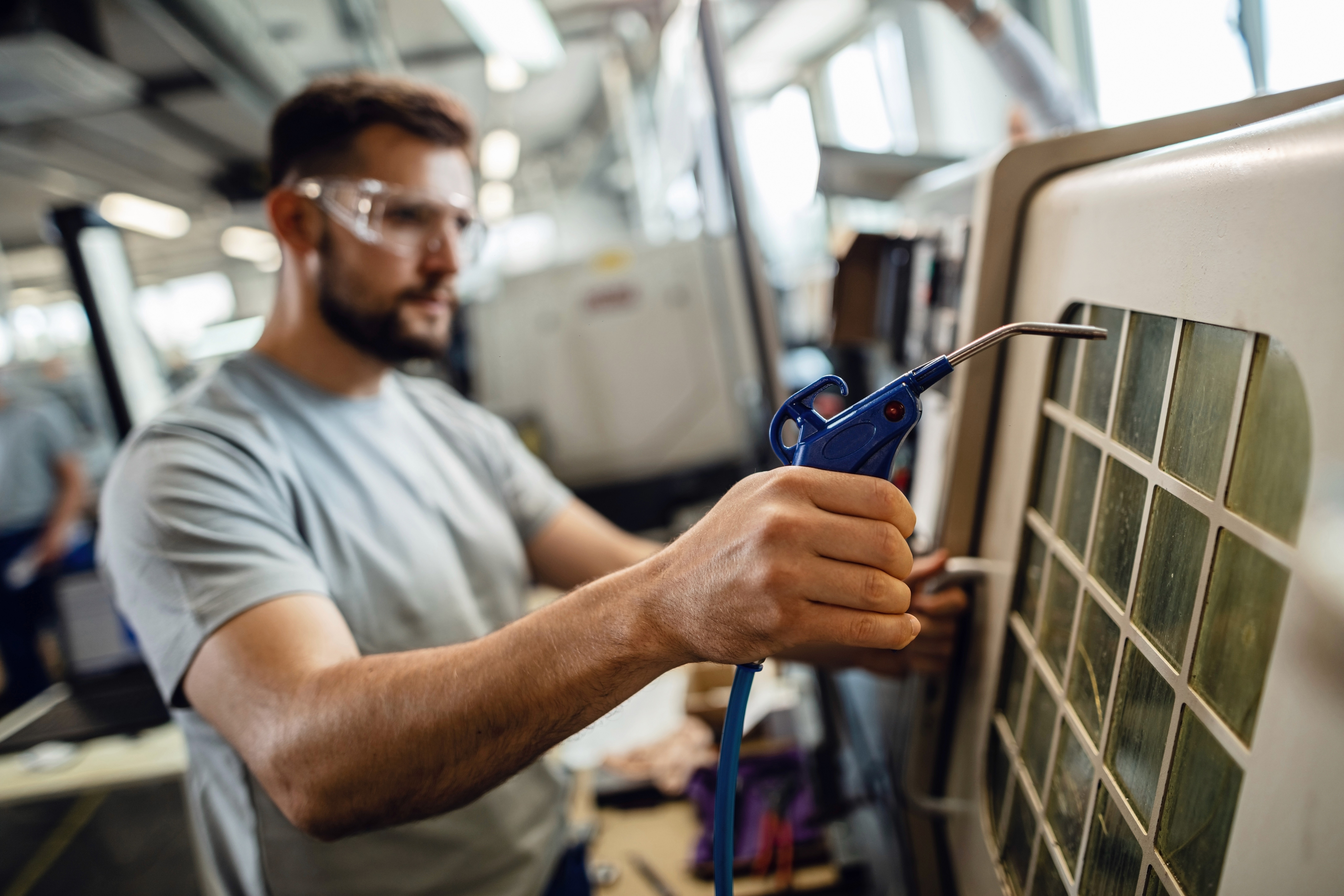 Technician cleaning an air conditioning condenser coil