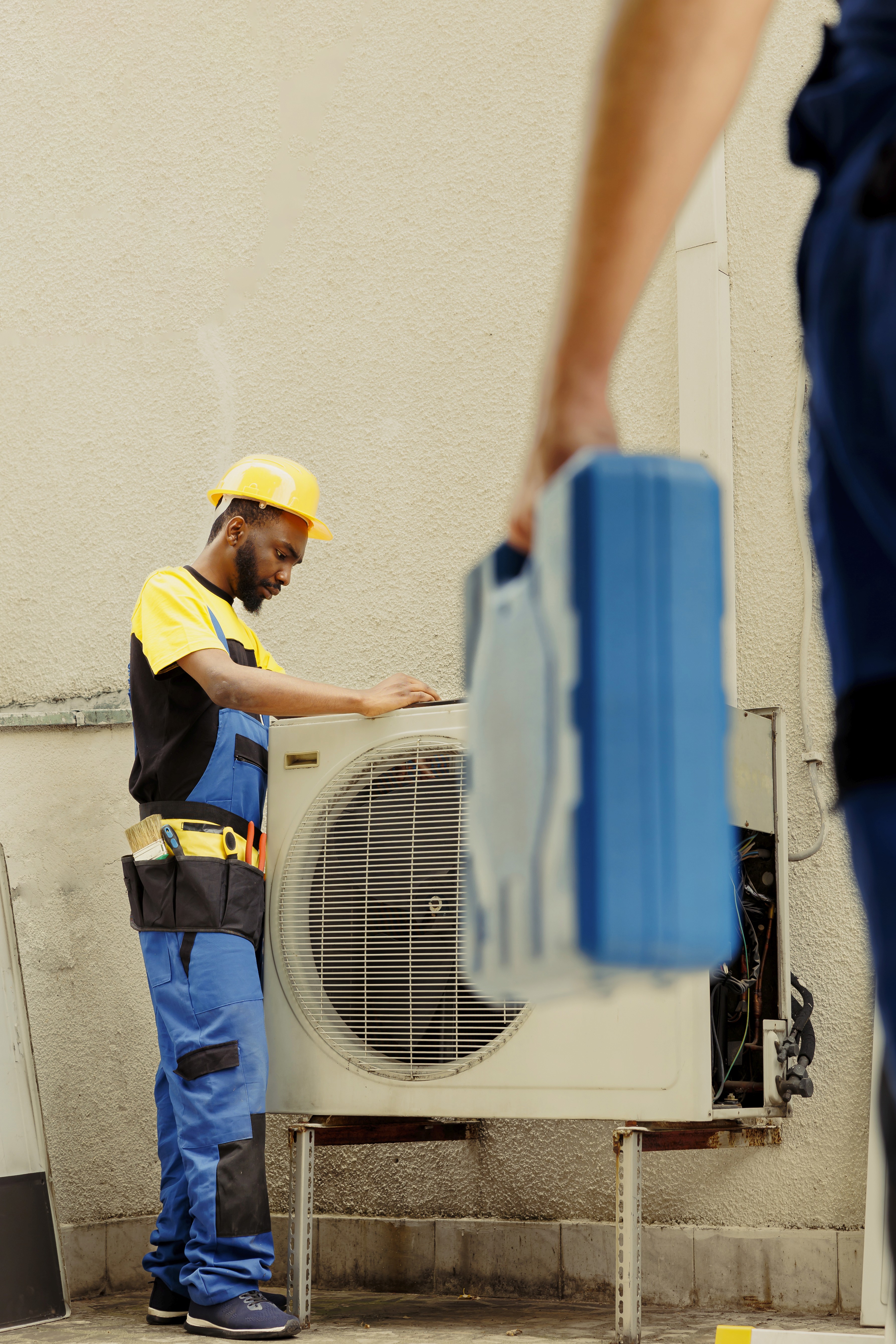 Technician carrying an outdoor air conditioning unit component